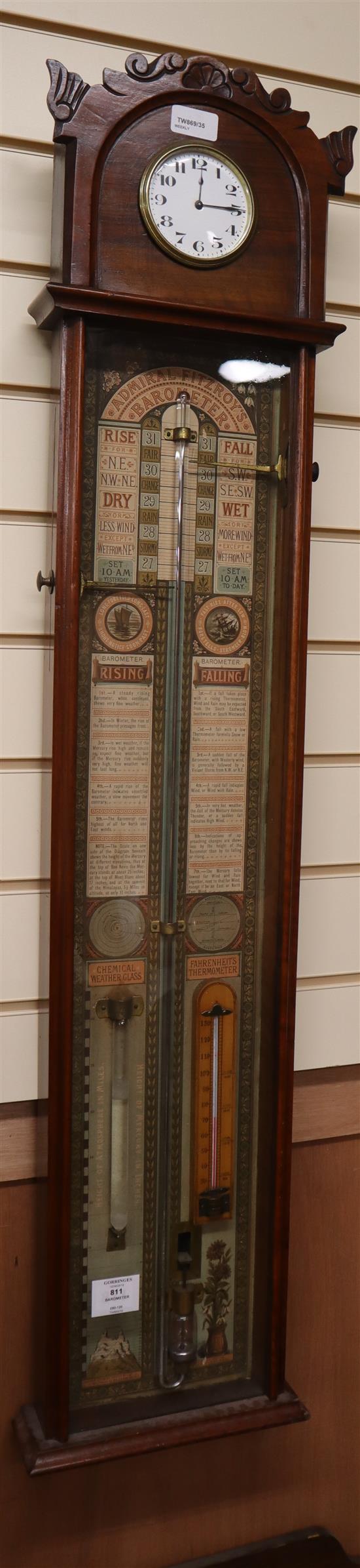 A Victorian Admiral Fitzroys barometer, in carved arched walnut case with printed paper scales and timepiece to pediment H.113cm